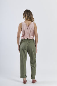 Combinazione top rosa lucido e pantaloni di colore verde militare, accento moderno
