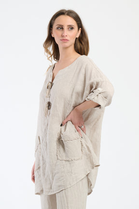 Outfit beige in lino, camicetta oversize e pantaloni coordinati, stile minimalista per l’estate.
