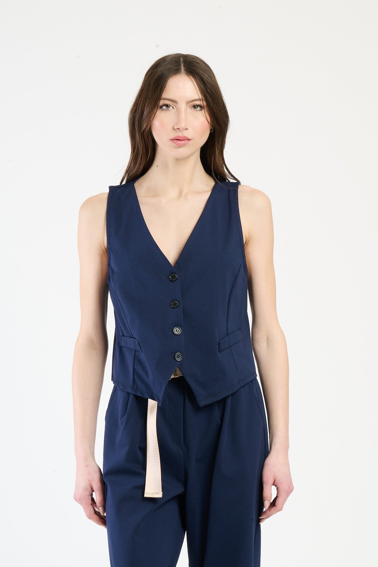 Completo navy su una modella: gilet a bottoni e pantaloni, combinazione sicura e accattivante.