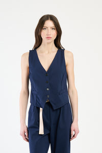 Completo navy su una modella: gilet a bottoni e pantaloni, combinazione sicura e accattivante.