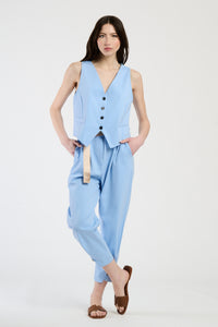Donna elegante con completo azzurro: gilet senza spalline e pantaloni, stile raffinato e moderno.