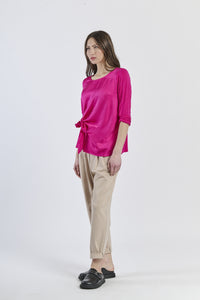 Blusa fuxia a maniche 3/4, abbinata a pantaloni neri, audacia stilistica