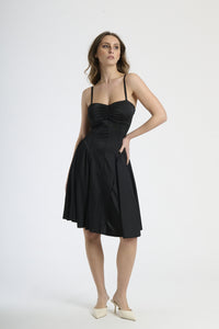 Abito nero con plissé sul busto, abbigliamento versatile e affascinante.