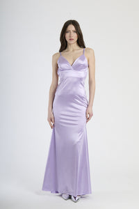 Donna con abito lilla in raso, originalità e charme magico.