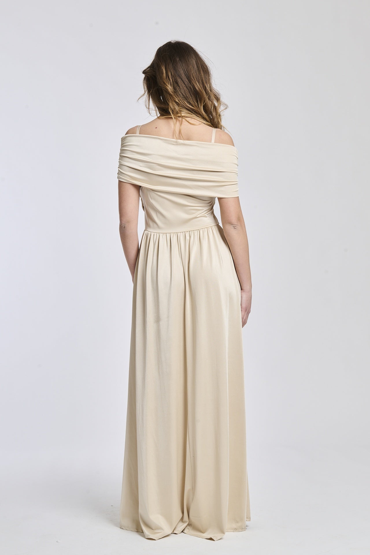 Abito beige a spalline scollate, tessuto fluido, fascia in vita che crea un’effetto drammatico.