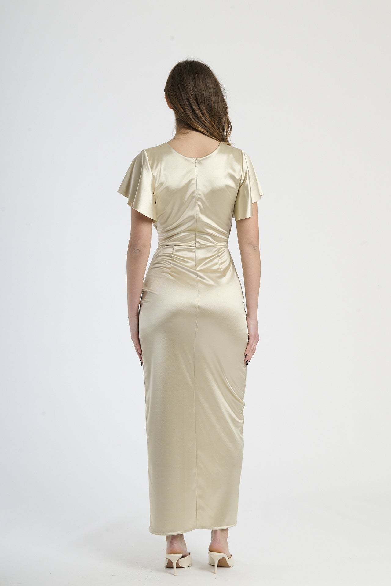 Modella in abito beige a scollatura V, stile classico per occasioni formali.