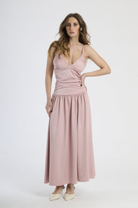 Abito lungo rosa antico con scollatura a V profonda, silhouette dritta e gonna fluttuante.