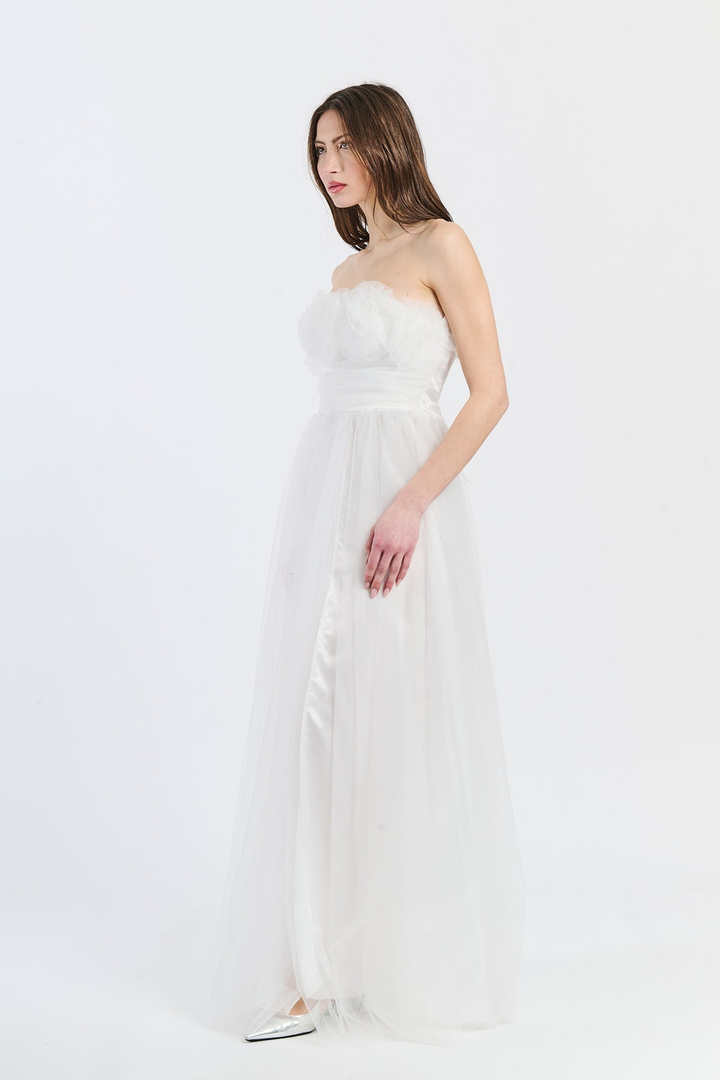 Abito formale bianco con tulle lustrato, scollo a barca e silhouette romantica, adatto per serate all’aperto e glamour