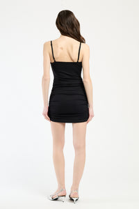 Modella con abito nero stretch, stile impeccabile e seducente.