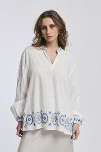 Ragazza indossa una giacca marrone di lana con maniche lunghe e collo a camicia, taglio regolare e bottoni in legno, abbinata a una gonna nera