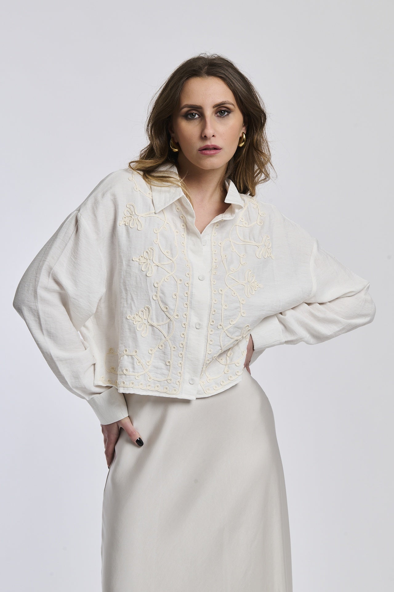 Camicia a righe blu scuro e bianco indossata dalla donna, con un leggero slittamento e un nodo alla vita, che trasmette un’atmosfera