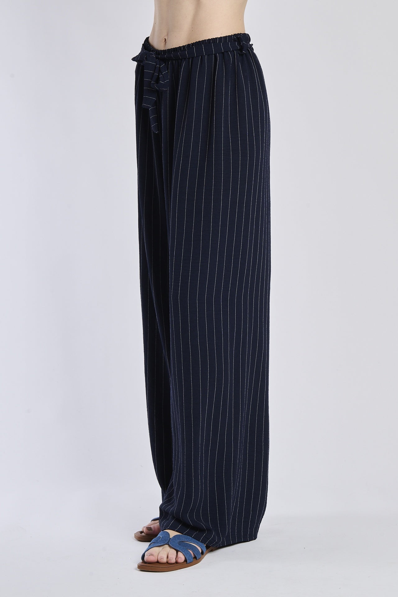 Pantaloni fluido navy, taglio ampio, nodo decorativo in vita, ideali per un look sofisticato.