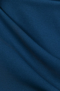 Donna indossa un abito ottanio senza maniche, lunghezza midi,