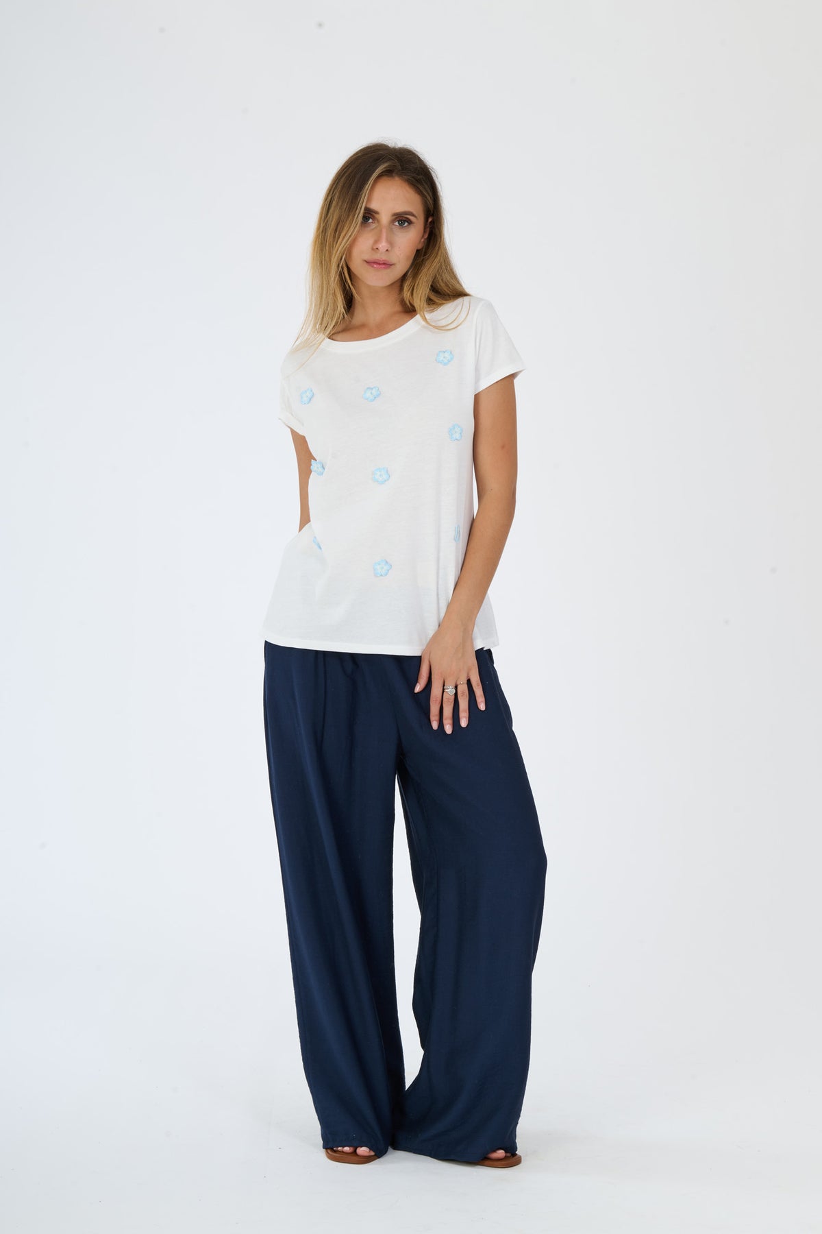 Outfit di stile quotidiano e confortevole: maglietta bianca a pois e pantaloni larghi scuri, esibizione di uno stile fashion rilassato