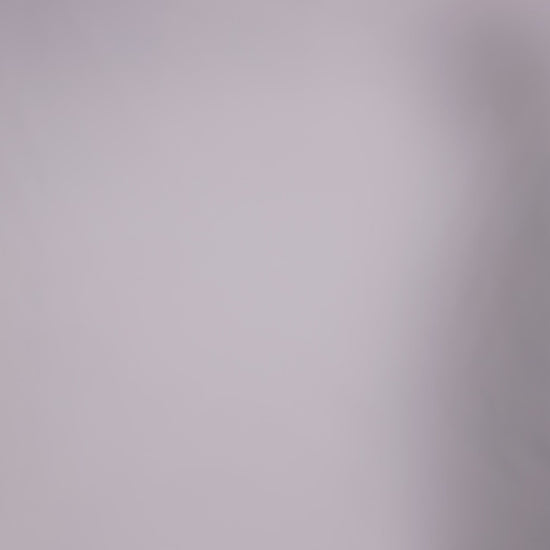 Donna con abito ottanio elegante, collo alto a imbarcatura, gonna lunga, foulard in tulle trasparente, look sofisticato e moderno.