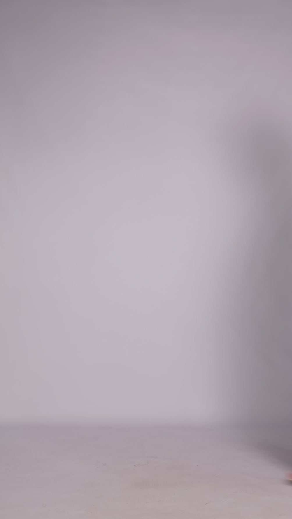 Donna con abito ottanio elegante, collo alto a imbarcatura, gonna lunga, foulard in tulle trasparente, look sofisticato e moderno.