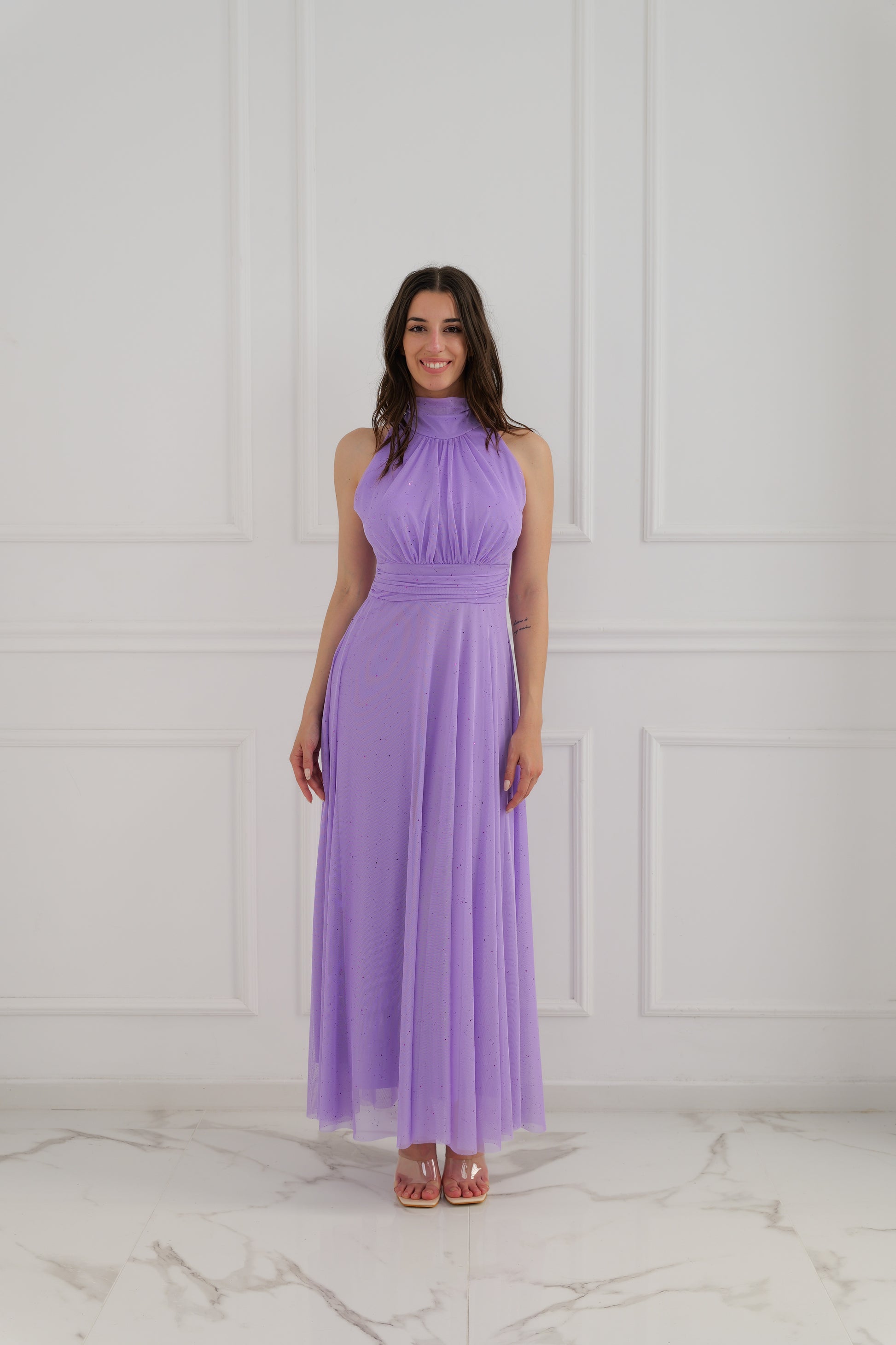 Modella con abito da sera lilla colletto alto, posa stilosa con bracci in alto