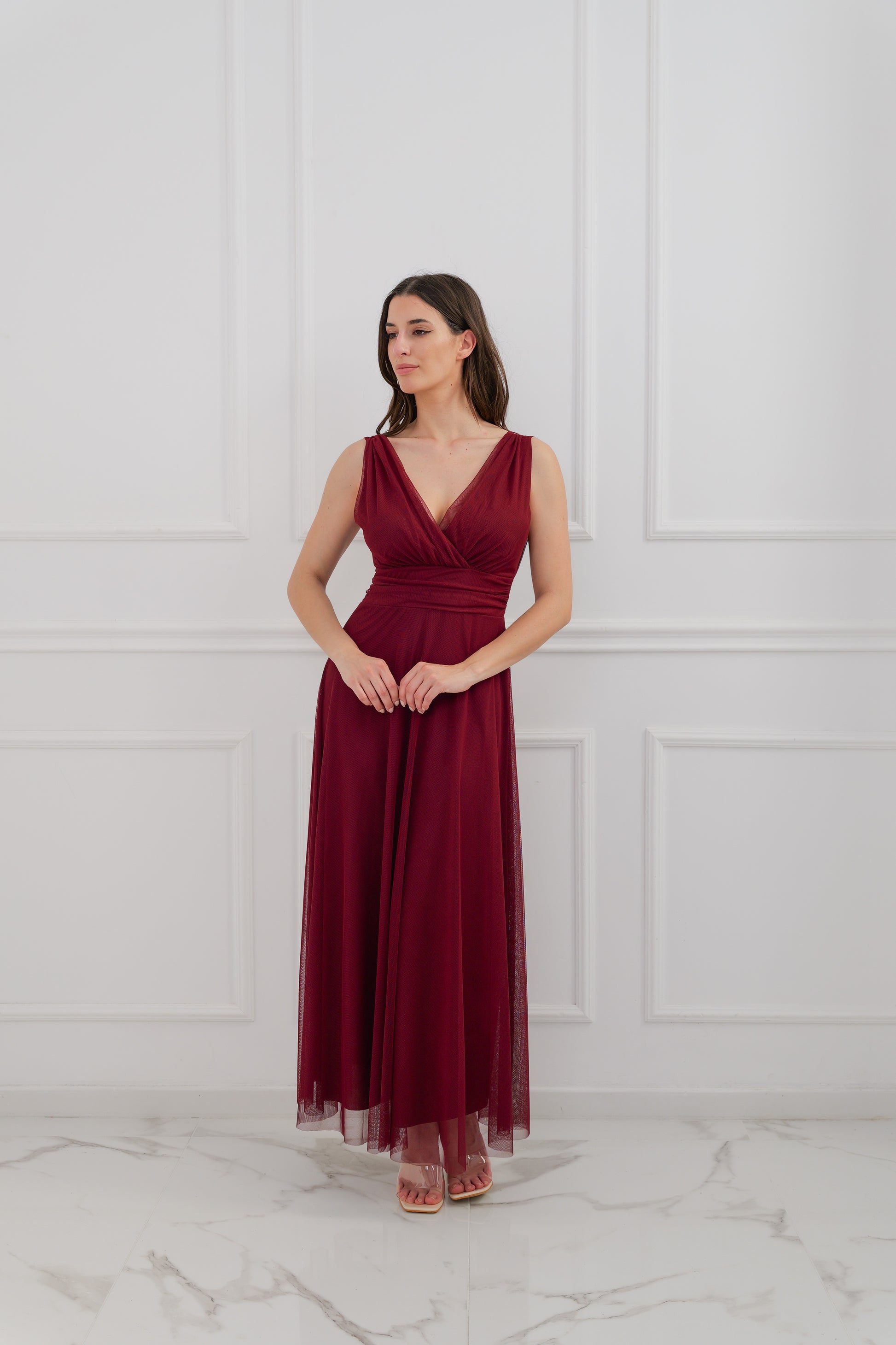 Questo abito bordeaux, con il colletto a V audace e la gonna in tulle fluido, è un vero simbolo di grazia. Perfetto per le occasioni in cui vuoi stupire, regala un’aria da protagonista delicata e affascinante