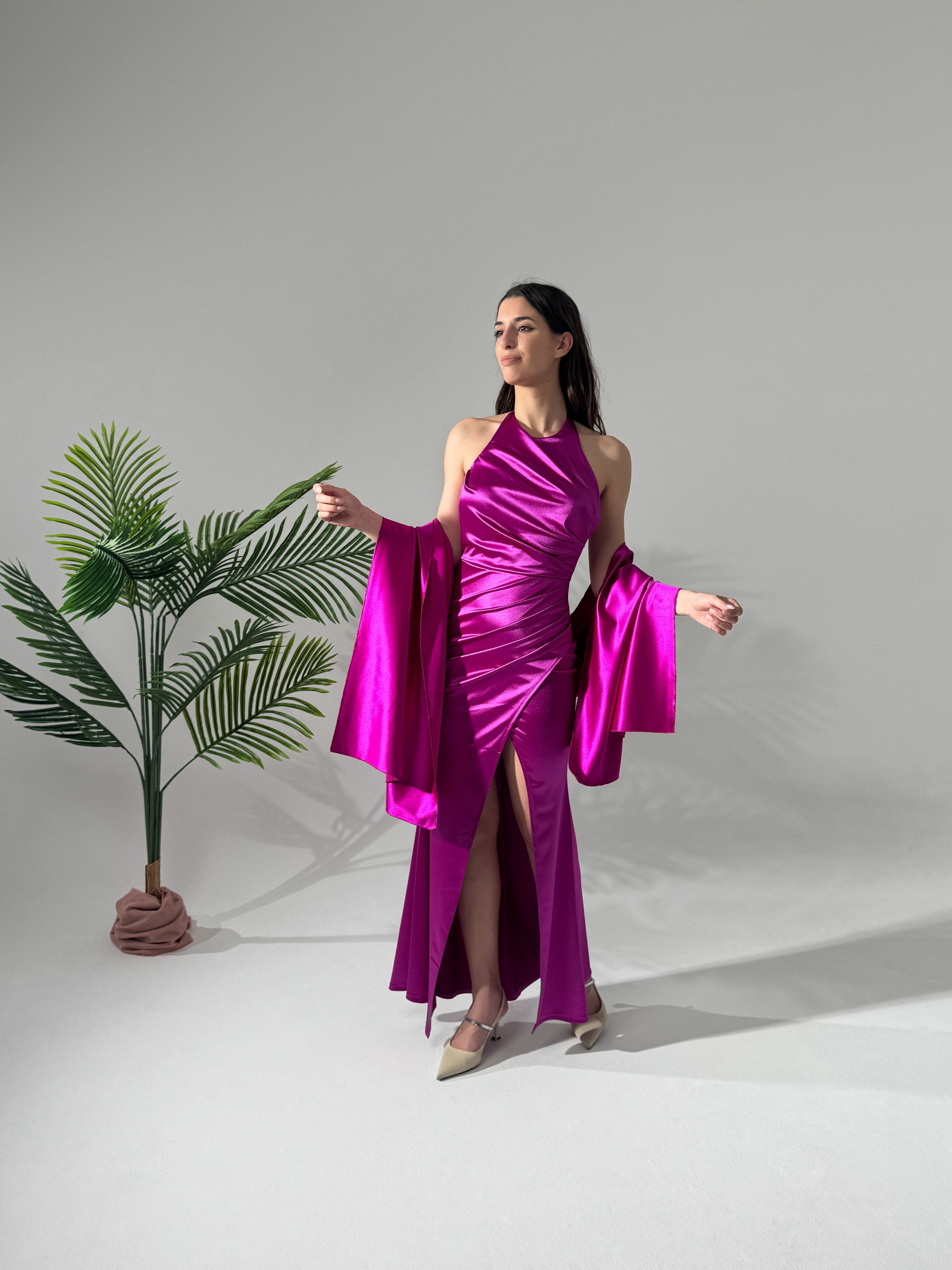 Abito viola satinato con spacco, scenario studio con pianta